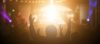 People worshipping in front of lit up cross